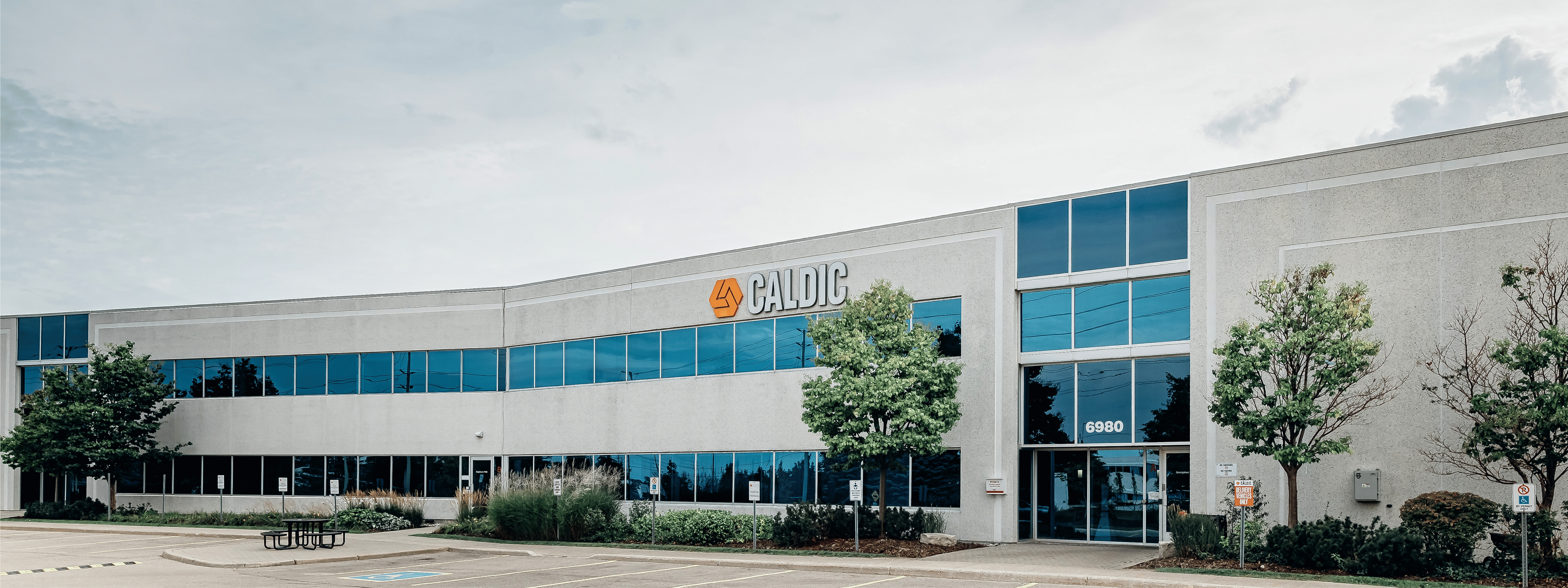 Caldic corporate office and distribution facility with modern glass frontage, landscaped grounds, and parking area